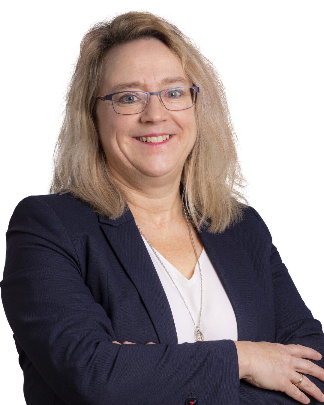 Portrait von Personalleiterin der Firma Sanit Gabi Karl im dunkelblauen Jackett mit weißem T-shirt darunter. Sie blickt freundlich läächelnd mit verschränkten Armen den Betrachter an.