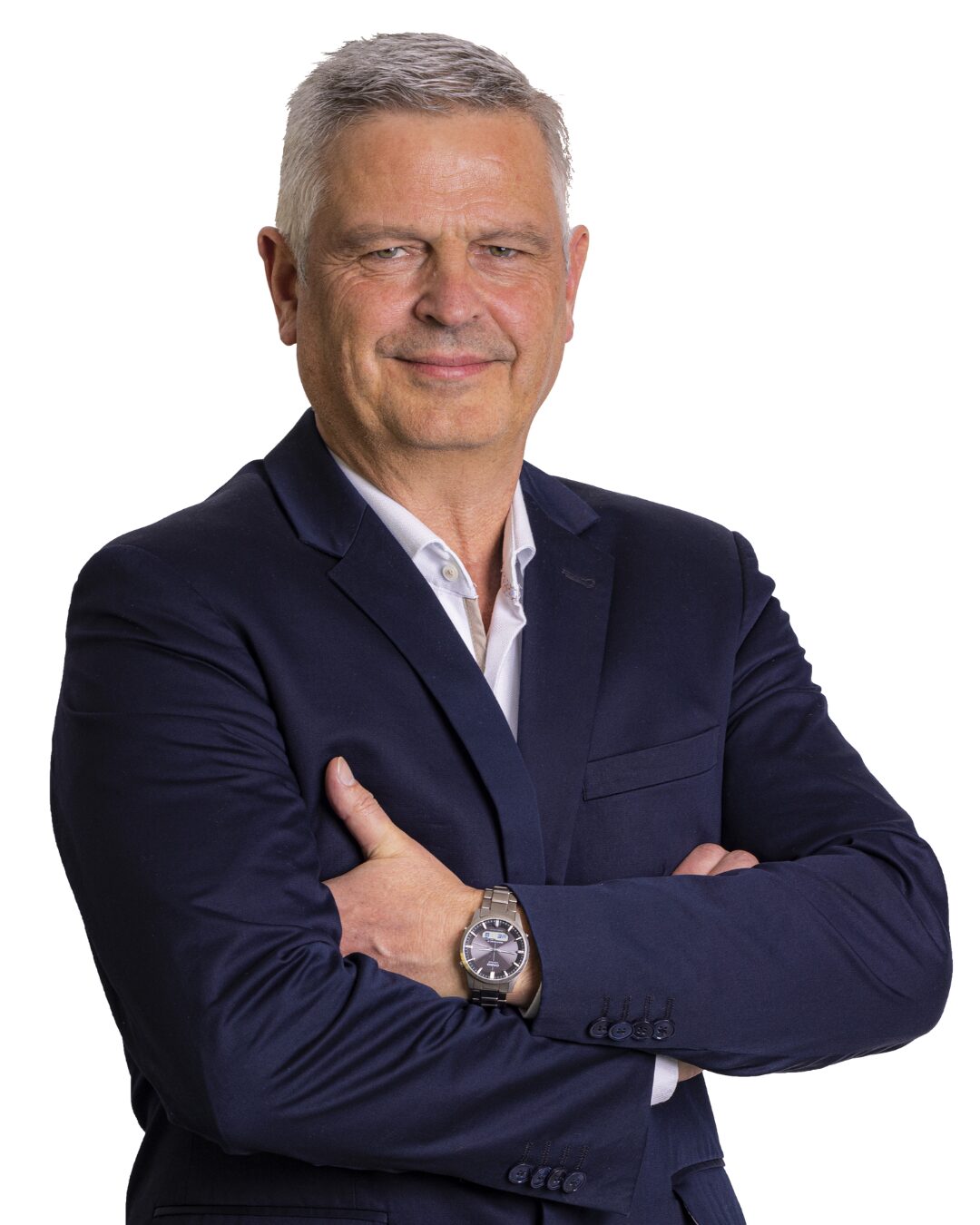 Bernhard Mücke – Entwicklungsleiter Portrait vom Entwicklungsleiter der Firma Sanit Bernhard Mücke im dunkelblauen Jackett mit weißem Hemd darunter. Er blickt mit verschränkten Armen den Betrachter an.